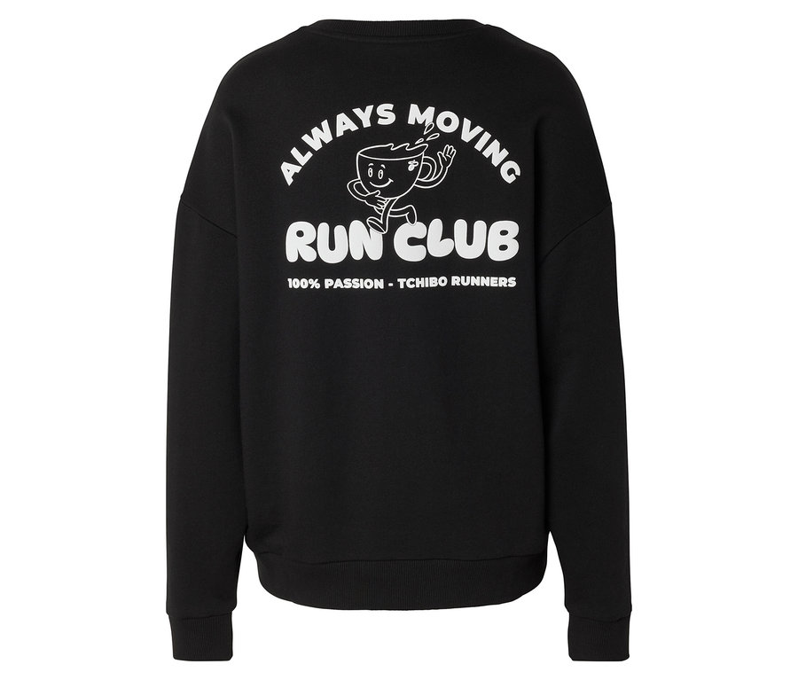 Fekete szabadidőfelső fehér grafikus mintával a hátán, amely egy futó kávéscsészét, az „ALWAYS MOVING RUN CLUB” szöveget és a „100% PASSION - TCHIBO RUNNERS” feliratot ábrázolja.