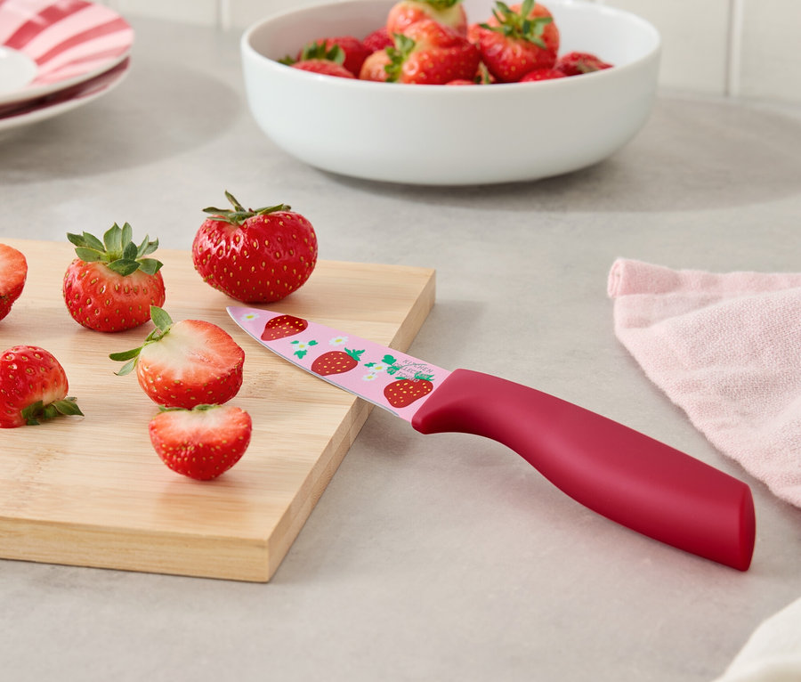 Eprek és egy eper mintás kés egy vágódeszkán.