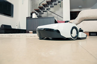 Elektromos segéd: Egy robotporszívó mozog a lelapozott nappali padlózatán.